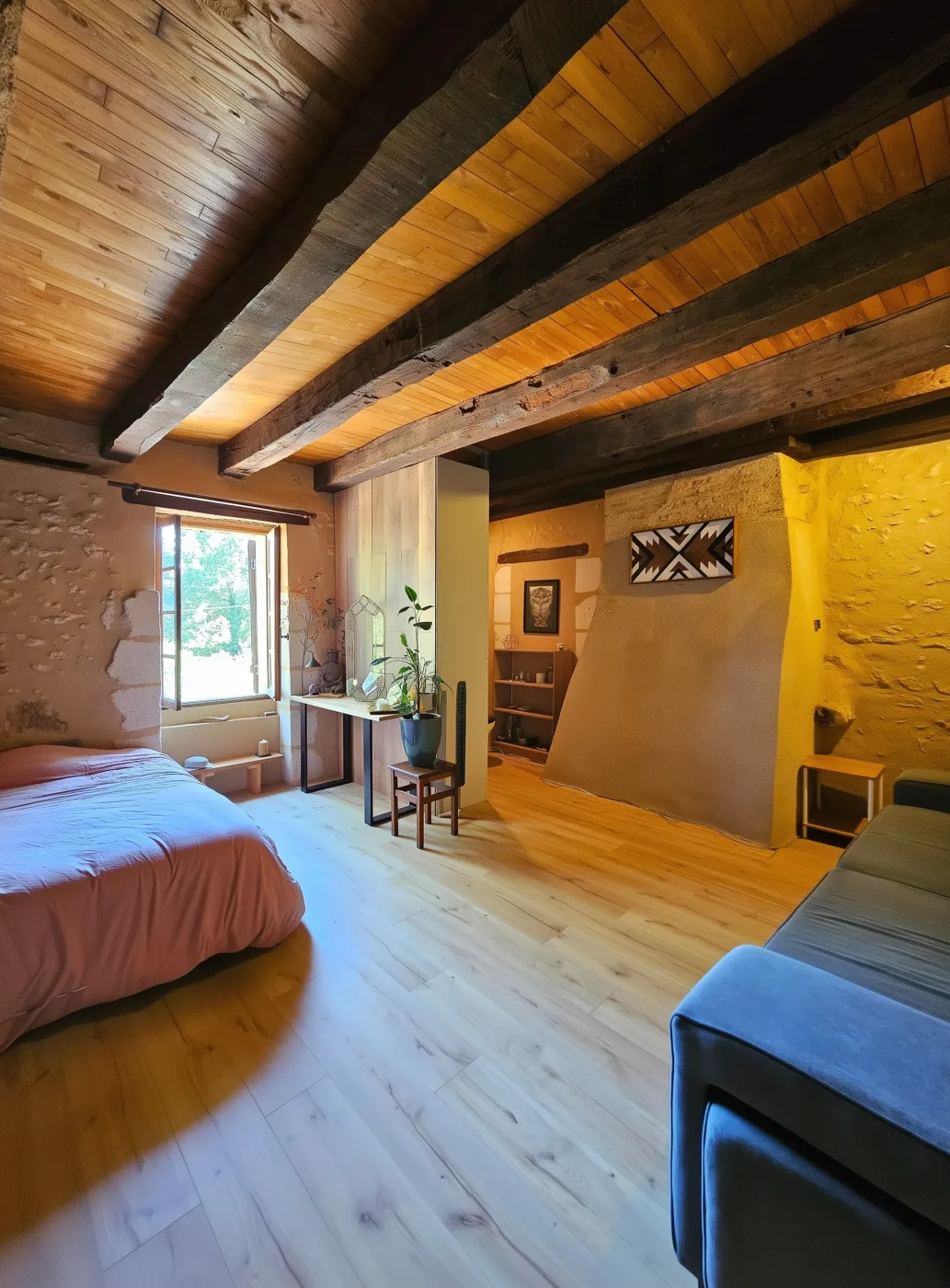 Chambre d'hôte du stage : lit deux places sous les poutres, atelier ArtiZi-OM