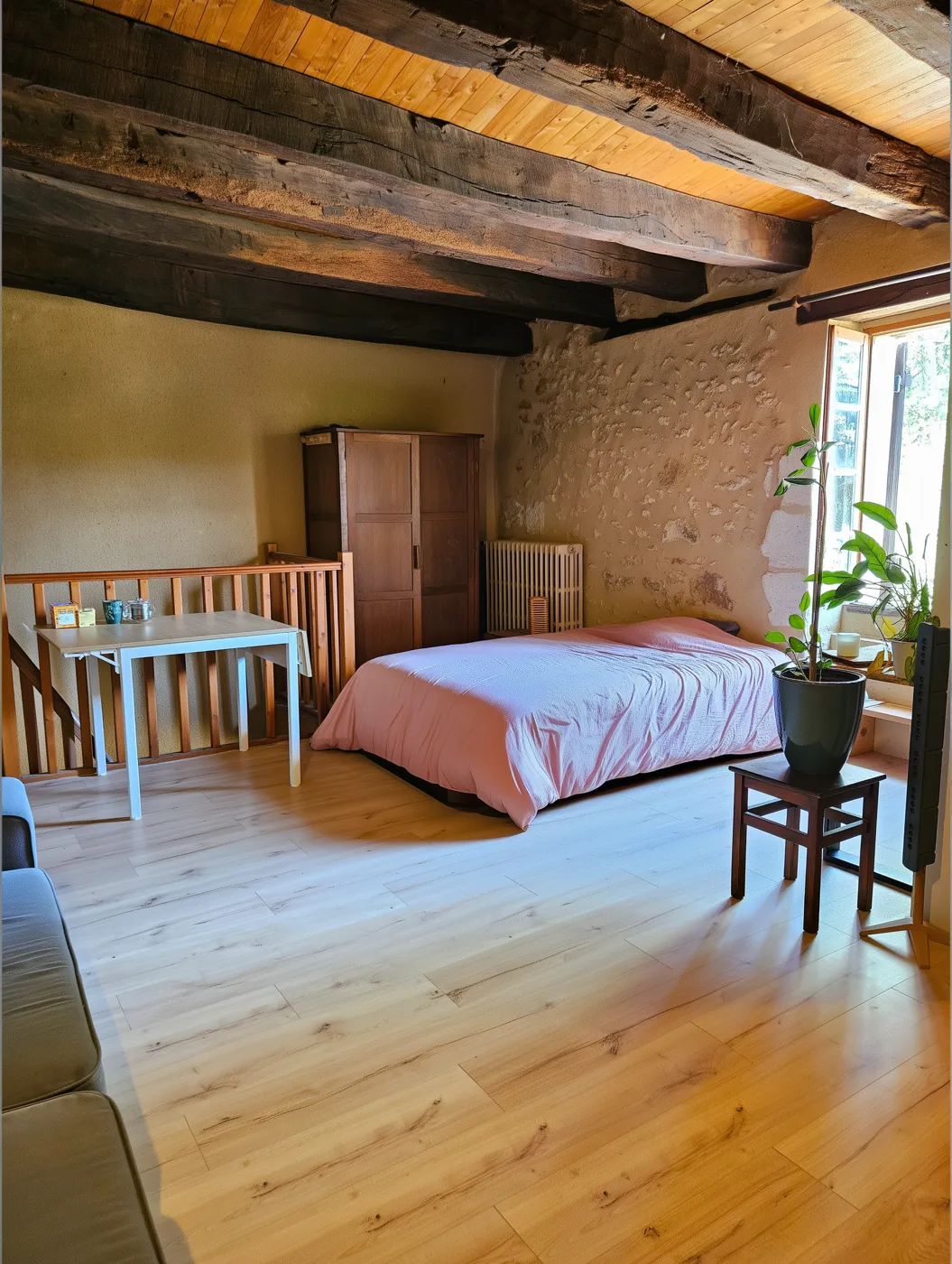 La chambre des stagiaires : lit, armoire ancienne et parquet clair