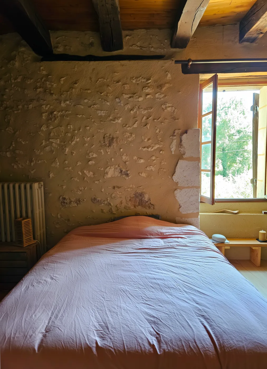 Tête de lit en pierre et lumière du matin, chambre des stagiaires